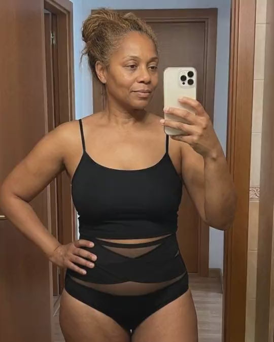 Femme en brassière noire et culotte taille haute, selfie dans le miroir
